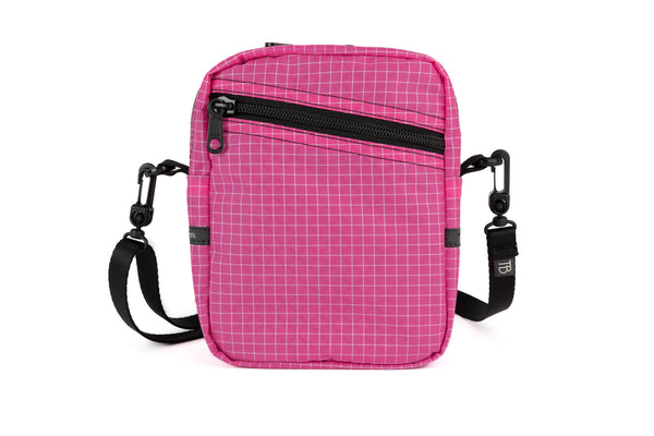 An Everyday Cubelet in Cerise Halcyon (pink with a white grid) with a front zipper.